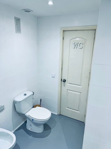 Baño compartido vista hacia el inodoro y la entrada